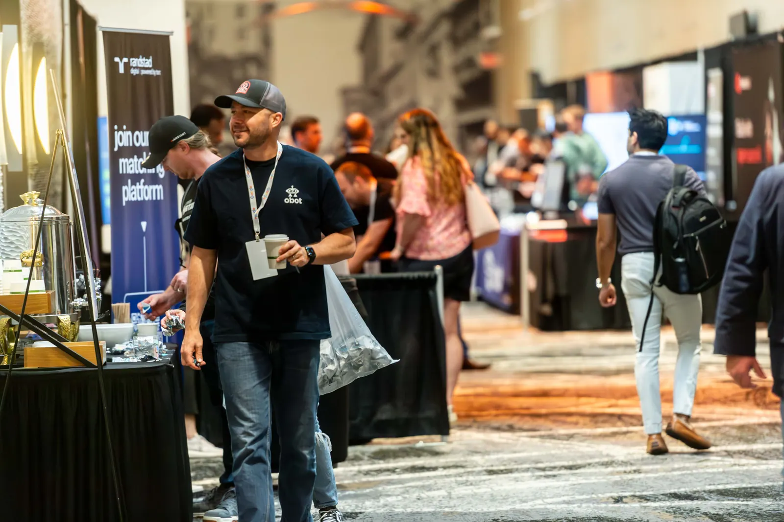 Attendees walking the sponsor tables along the expo aisle at All Things AI 2026