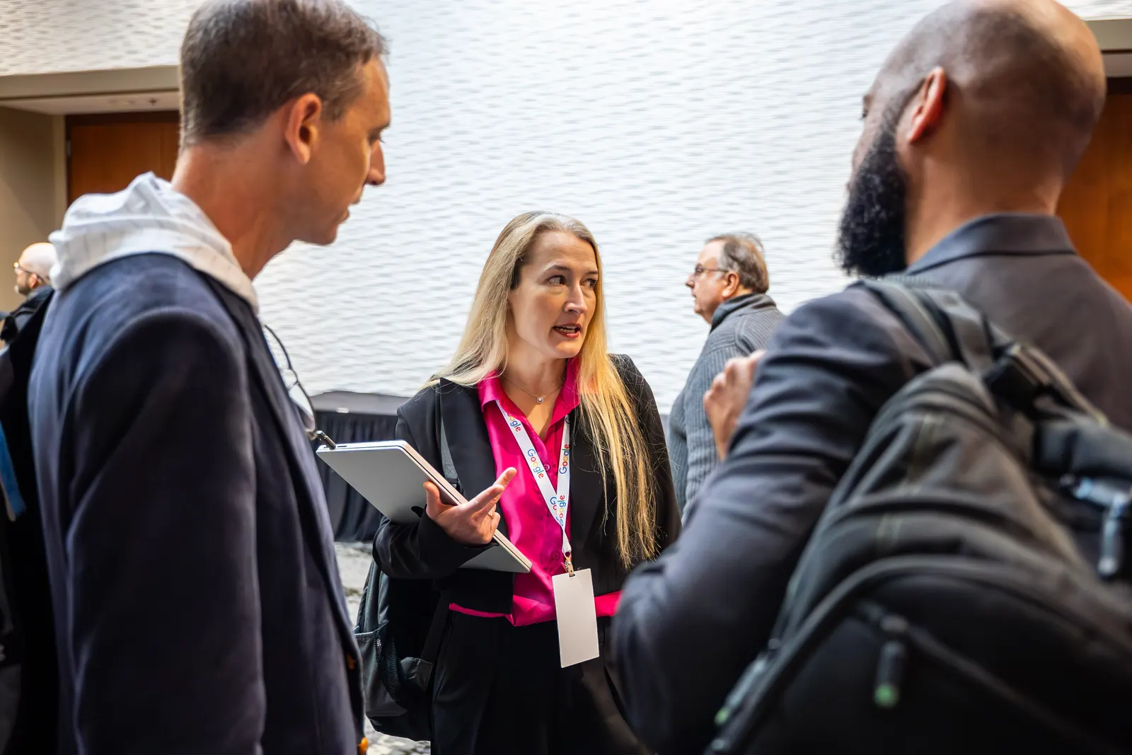 Three attendees talking face to face between sessions at All Things AI 2026