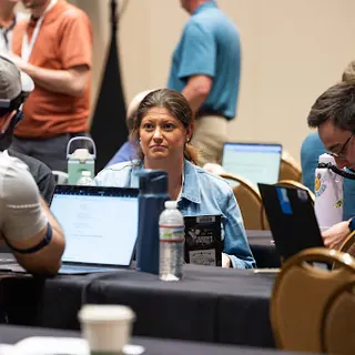 People working together at laptops during an All Things AI workshop